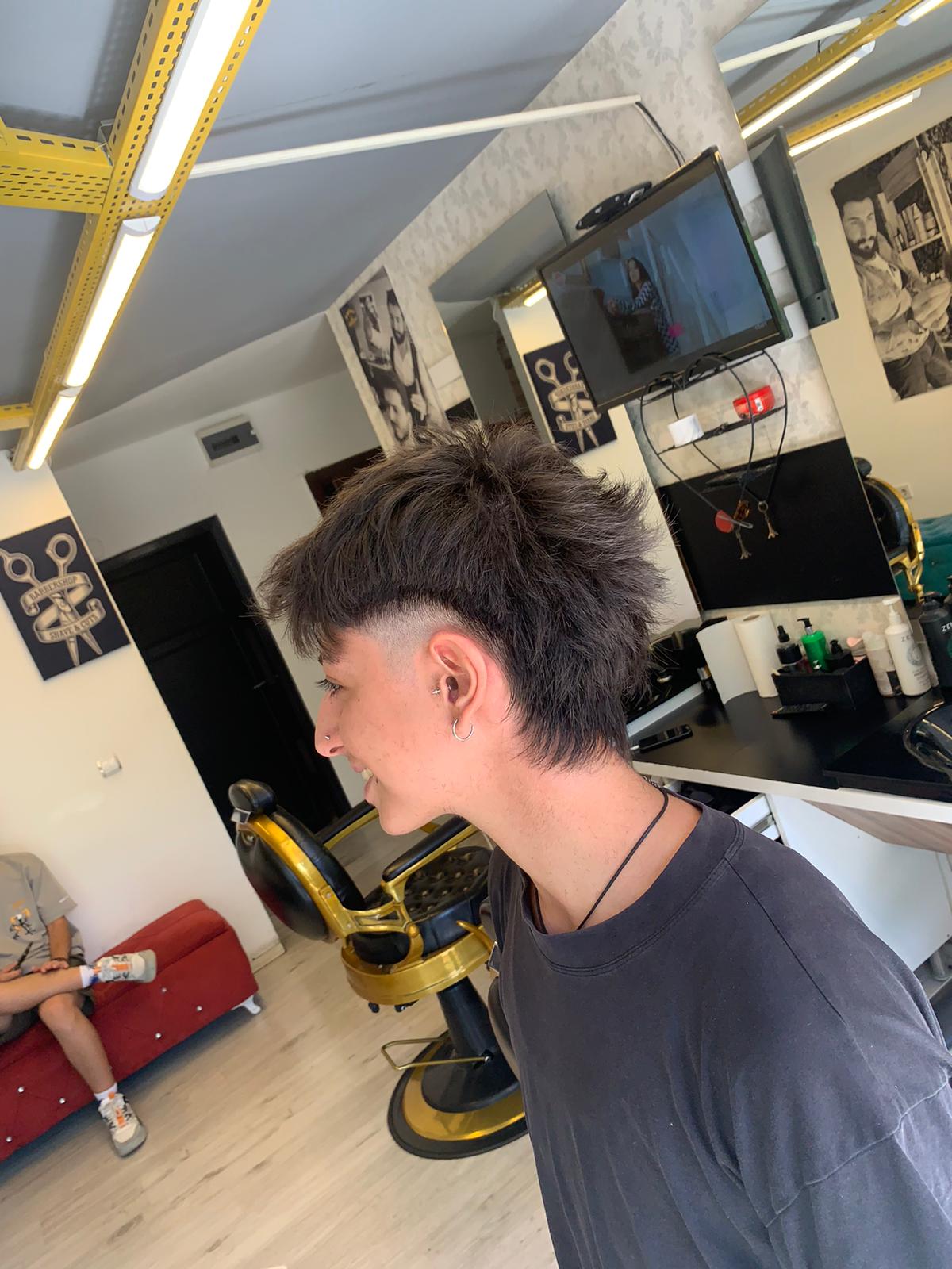 Pariss Berber salon içi — klasik altın berber koltuğu ve kesim anı